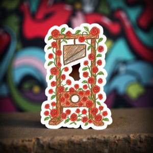May include: A sticker featuring a brown guillotine design, adorned with red roses and green leaves. The guillotine has a brown blade and is surrounded by a floral arrangement. The background is a colorful graffiti wall.