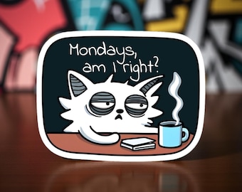May include: A white sticker with a cartoon cat with tired eyes, a coffee cup, and the text "Mondays, am I right?" The cat is sitting at a table with a book. The background is dark blue with a white border.