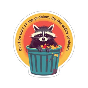 May include: A sticker featuring a raccoon in a teal trash can, surrounded by yellow and orange accents. The raccoon has a black and white face and is surrounded by trash. The text reads, "Don't be part of the problem. Be the entire problem."