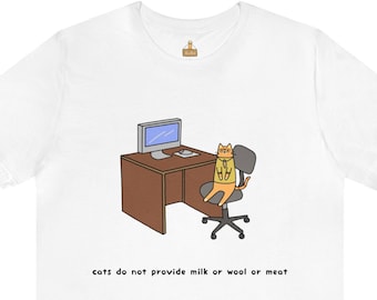 May include: White t-shirt featuring a cartoon cat sitting at a desk with a computer. The cat is wearing a yellow shirt and sitting in a gray office chair. The text "cats do not provide milk or wool or meat" is below the desk.