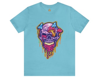 Op de afbeelding: Een lichtblauw t-shirt met een afbeelding van een paarse schedel met paddenstoelen die uit zijn oogkassen groeien en rode en oranje verf druppelen.