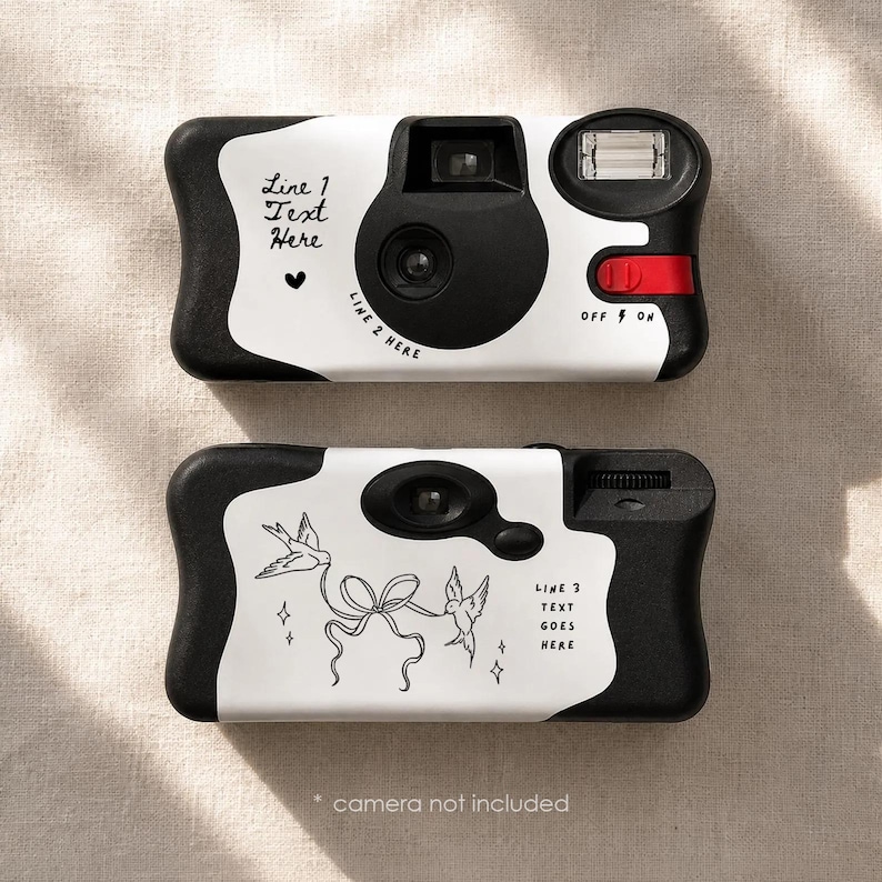May include: Two white and black disposable camera covers featuring custom text areas. The top cover displays Line 1 Text Here, a heart icon, and Line 2 Here. The bottom cover shows a line art illustration of two birds holding a ribbon and Line 3 Text Goes Here.