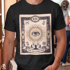May include: A black t-shirt featuring a graphic print of a tarot card design. The card displays a central eye within a gear, surrounded by intricate borders, symbols, and the text "XIV" and "THE ALGORITHM" at the bottom of the illustration.