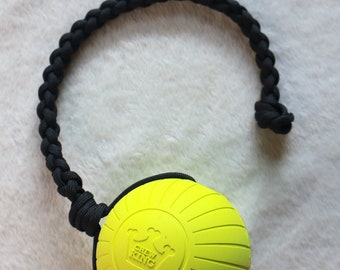 May include: A bright yellow rubber dog chew toy with a black braided rope handle. The toy has a raised design and the words "CHEW KING" printed on it.