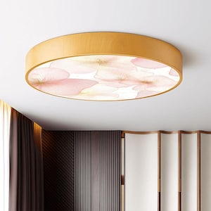 May include: A round flush-mount ceiling light fixture with a light wood frame. The light features a floral design with pink and white watercolor-style flowers. The fixture is mounted on a white ceiling.