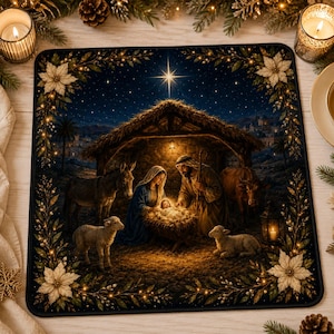 May include: A square decorative mat featuring a nativity scene with a central star, a stable, and figures of Mary, Joseph, and the infant Jesus. The scene is surrounded by a border of white poinsettia flowers and green foliage with small lights.