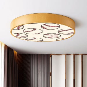 May include: A round ceiling light fixture with a light wood frame. The center of the light features a pattern of baseballs with red stitching on a cream background. The fixture is mounted on a white ceiling.
