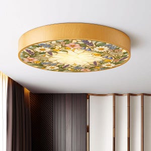 May include: A round flush mount ceiling light fixture featuring a light wood grain frame and a circular glass panel decorated with a colorful floral pattern of daisies, lavender, and pink blossoms surrounding a central white flower design.