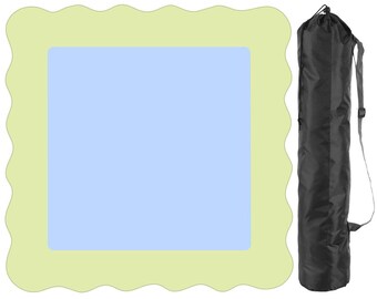 Op de afbeelding: Een lichtblauwe en groene decoratieve mat met een golvende rand. Naast de mat staat een zwarte cilindrische tas met een schouderriem. De tas is afgesloten met een trekkoord.