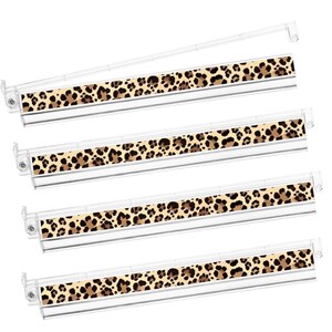 May include: Four clear plastic label holders with a leopard print design. The leopard print is a mix of brown and black spots on a tan background. The holders are angled slightly, showing the design.
