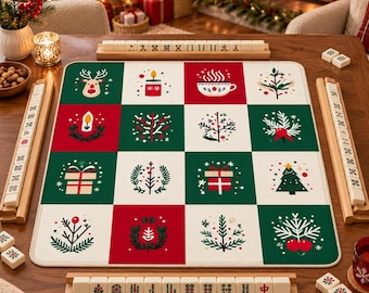 May include: A square mahjong mat featuring a grid of sixteen alternating red, green, and white squares decorated with Christmas icons including reindeer, candles, mugs, gifts, and pine trees, accompanied by four wooden tile racks and mahjong tiles.