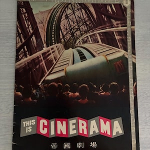 Peut inclure: Affiche vintage de Cinerama représentant une scène de montagnes russes avec une foule de personnes. L'affiche porte les mots "THIS IS CINEMARA" en grandes lettres, avec du texte japonais en dessous. Le fond est sombre avec une bordure de notes de musique.