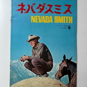 May include: A vintage movie poster for "Nevada Smith" in English and Japanese. The poster features a man in a cowboy hat, squatting on a small hill, with a horse nearby. The background shows a mountain range and a blue sky.