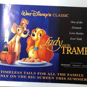 Può includere: Un poster del film "Lilli e il Vagabondo" della Disney mostra i due cani che condividono gli spaghetti. Il poster ha il testo "Walt Disney's Classic" e "Timeless Tails for All the Family. Only on the Big Screen This Summer."