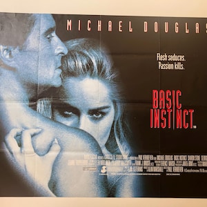 Może przedstawiać: Plakat filmowy do filmu "Instynkt Pierwotny" z Michaelem Douglasem. Plakat przedstawia zbliżenie Michaela Douglasa i Sharon Stone, z tytułem filmu w czerwonych literach. Hasło filmu to "Flesh seduces. Passion kills."