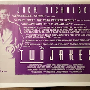 May include: A purple and white movie poster for the film "The Two Jakes" starring Jack Nicholson. The poster features a close-up of Jack Nicholson's face and the title of the film in large, bold letters. The poster also includes several quotes from reviews of the film.