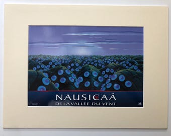 May include: A blue and purple poster with the title "Nausicaä of the Valley of the Wind" in red and white text. The poster features a field of blue and green orbs against a purple sky.
