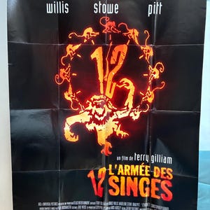Puede incluir: Un cartel de la película "12 Monos" con Bruce Willis, Madeleine Stowe y Brad Pitt. El cartel tiene un fondo negro con gráficos naranjas y amarillos de monos y el título de la película en texto grande y estilizado.
