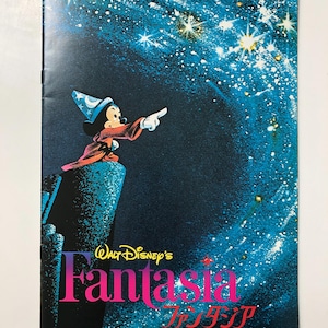 May include: A vintage poster for the Walt Disney film Fantasia, featuring Mickey Mouse as the Sorcerer's Apprentice pointing at a starry sky. The poster is in Japanese and English, with the title "Fantasia" in pink and purple lettering.