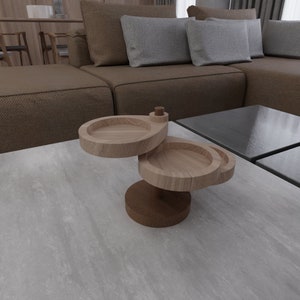 May include: A wooden two-tiered serving tray with a round top and a smaller round bottom. The tray is made of light brown wood and has a natural finish.