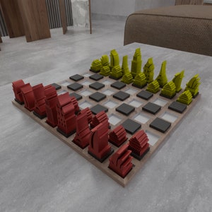 May include: A wooden chessboard with red and yellow chess pieces shaped like buildings. The board has a black and white checkered pattern.