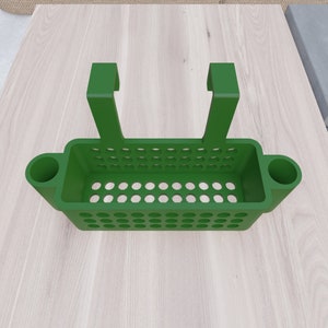May include: Green plastic hanging shower caddy with two side hooks and two side compartments. The caddy has a rectangular shape with a grid pattern.