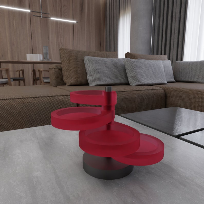 May include: A red, four-tiered, rotating jewelry organizer with a black base. The organizer is made of glass and is sitting on a gray surface.