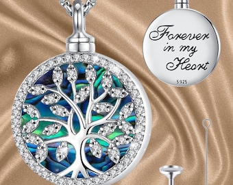 May include: A silver-colored tree of life pendant necklace. The pendant features a round design with a tree motif, surrounded by clear crystals and a blue-green iridescent background. The back of the pendant has the inscription "Forever in my Heart".