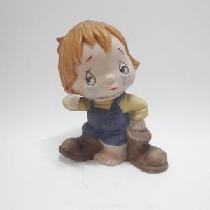 Vintage keramieken babyfiguurtje huilend met laarsje bij de hand