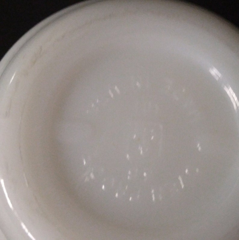 May include: White ceramic bowl with a raised rim and a small, embossed logo on the bottom. The logo reads "Made in USA" and "Pyrex".