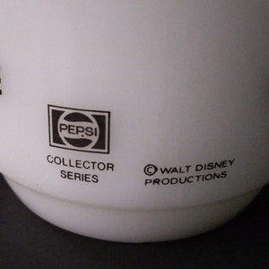 May include: White ceramic mug with a black Pepsi logo, "Collector Series" and "&copy; Walt Disney Productions" text.