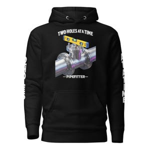 Puede incluir: Sudadera con capucha negra con un gráfico que muestra una conexión de tubería y un nivel. El texto dice "TWO HOLES AT A TIME" encima de la conexión y "-PIPEFITTER-" debajo. Texto blanco en las mangas.