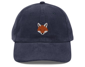 May include: A navy blue corduroy baseball cap with an embroidered fox face in orange and brown.