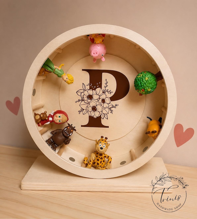May include: A wooden, circular display shelf with a large letter "P" and floral design. The shelf contains various small toy figurines, including a giraffe, pig, and other characters. The shelf is on a wooden base.