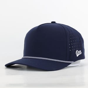 May include: A navy blue baseball cap with a white rope trim and a white "Oxe" logo on the side. The cap has a mesh back panel.
