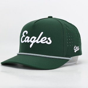 May include: A dark green baseball cap with the word "Eagles" in white script across the front. The cap has a curved brim, a white and grey rope detail, and a small logo on the side. The cap is made of a breathable material.
