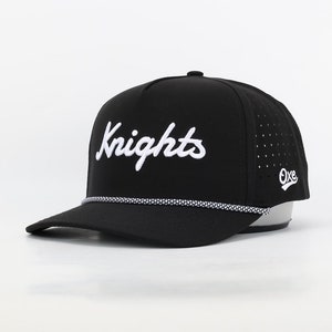 May include: Black baseball cap with a white rope trim and a white "Knights" logo embroidered on the front. The cap has a white "Oxe" logo on the side.