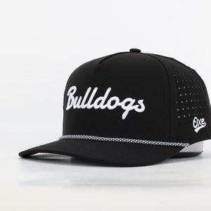 May include: Black baseball cap with a white rope detail around the brim. The cap has a white embroidered logo that says "Bulldogs" and a small white logo that says "Oxe" on the side.