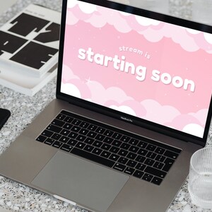 Op de afbeelding: Een laptop met een roze en wit scherm waarop de tekst "stream is starting soon" staat met een wolkenachtergrond.