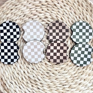 May include: Six round checkered car coasters in black and white, beige and white, brown and white, green and white, beige and white, and brown and white.