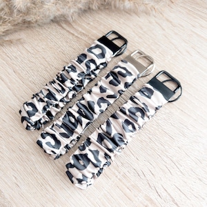 May include: Three black and beige leopard print watch bands with silver and black buckles.