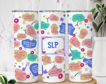 May include: Three white tumblers with colorful floral designs and motivational phrases. The tumblers feature phrases like "I radiate positivity", "I am capable", and "The work I do matters".