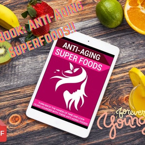 Puede incluir: Una tableta que muestra una portada de libro electrónico titulada "Anti-Aging Super Foods" con la silueta de una mujer y texto. La imagen está rodeada de fruta fresca, incluyendo fresas, naranjas y kiwis, sobre una superficie de madera. Las palabras "forever young" están escritas en cursiva.