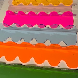 Wavy acrylic shelf 19”, multiple color options: Neon pink, orange, yellow, blue, emerald green, and peony pink. (Comes w/screws and anchors)