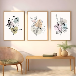May include: Three framed prints with black line drawings of floral bouquets on a white background. Each print features a different bouquet with pastel colored abstract shapes behind them.
