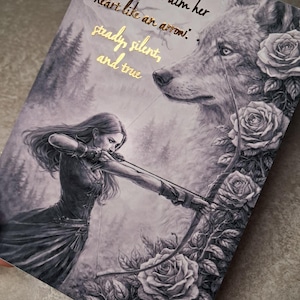 Op de afbeelding: Een zwart-wit illustratie van een vrouw die een pijl en boog richt, met een wolf en rozen op de achtergrond. De tekst luidt: "Ze leerde haar hart te richten als een pijl: standvastig, stil en waar."
