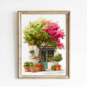 Könnte beinhalten: Ein gerahmter Kunstdruck, der ein Ladenlokal mit einer türkisblauen Tür zeigt, mit einem großen Baum mit grünen Blättern, orangefarbenen Früchten und leuchtend rosa Blüten. Mehrere Topfpflanzen stehen vor der Fassade des Gebäudes.