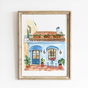 May include: Watercolor painting of a charming blue building with a red-tiled roof and a balcony adorned with flower boxes. The building has blue awnings, windows, and a door. Potted plants and small tables and chairs are in front of the building. The artwork is framed.