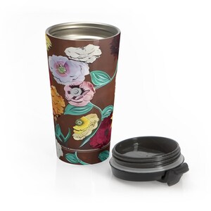 swifty travel mug with surprise piano design and flip top lid laying on ground, stainless steel coffee tumbler