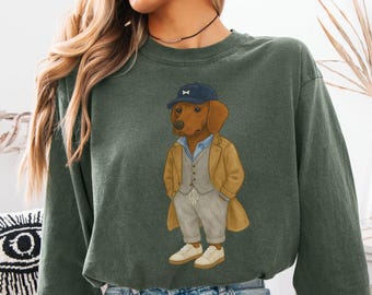 May include: Dark green sweatshirt with a cartoon dachshund wearing a blue cap, tan overcoat, and grey suit. The dog is also wearing white trainers. The word "HEMP" is printed at the bottom of the image.